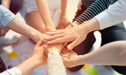 Background of diversity human bare hands join together in the middle under with warm natural sun light, Concept power of social network or volunteer's to be unity help and support the network society.